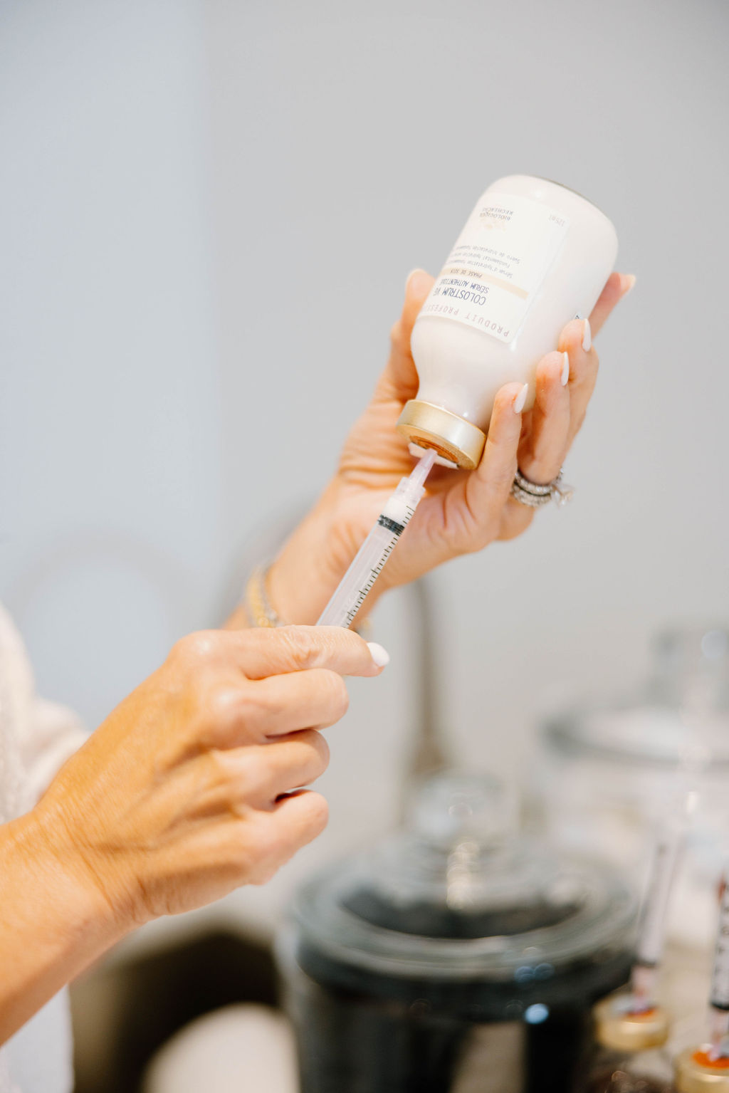 Hands drawing serum into a syringe