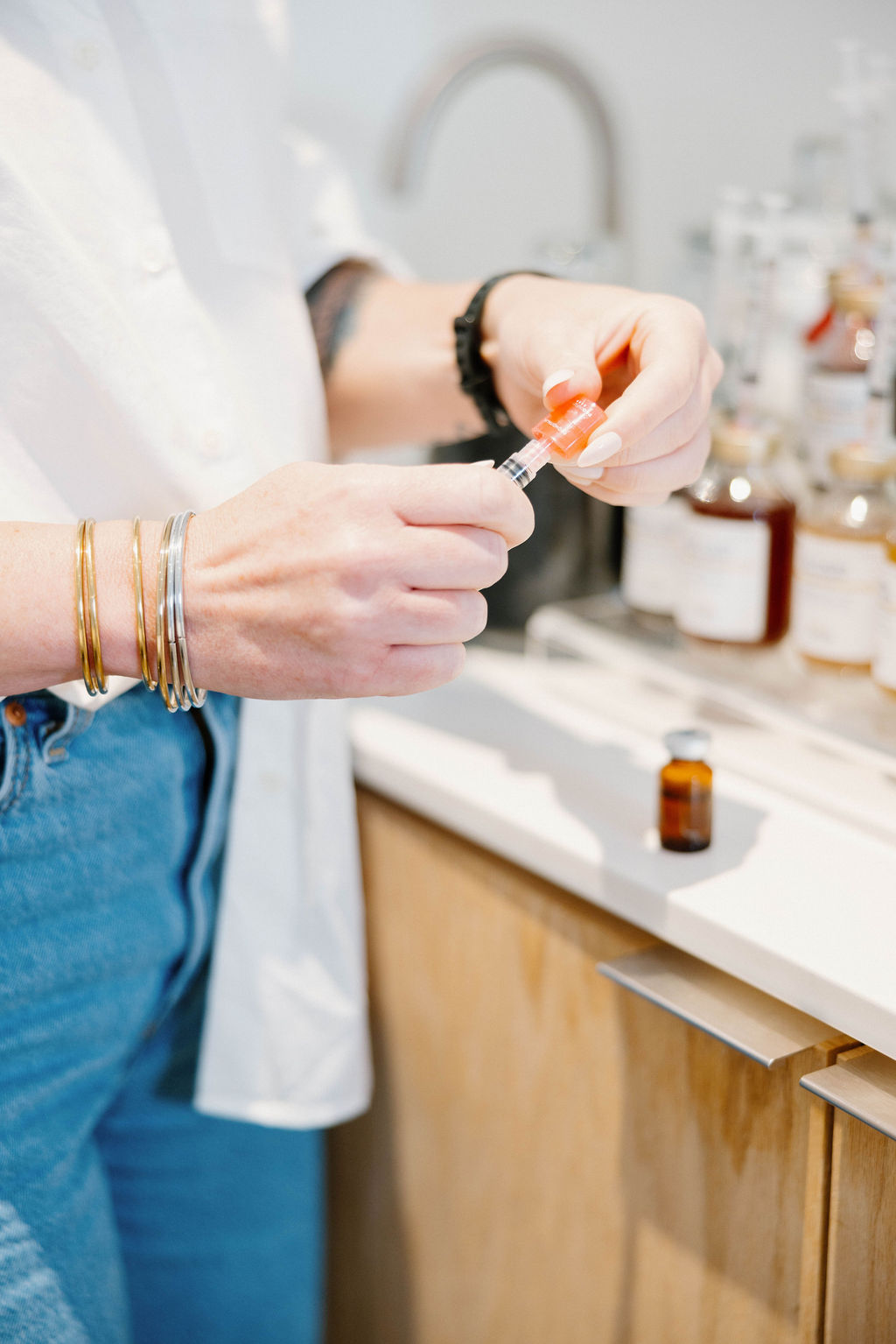 Hands preparing a syringe in a bright clinic