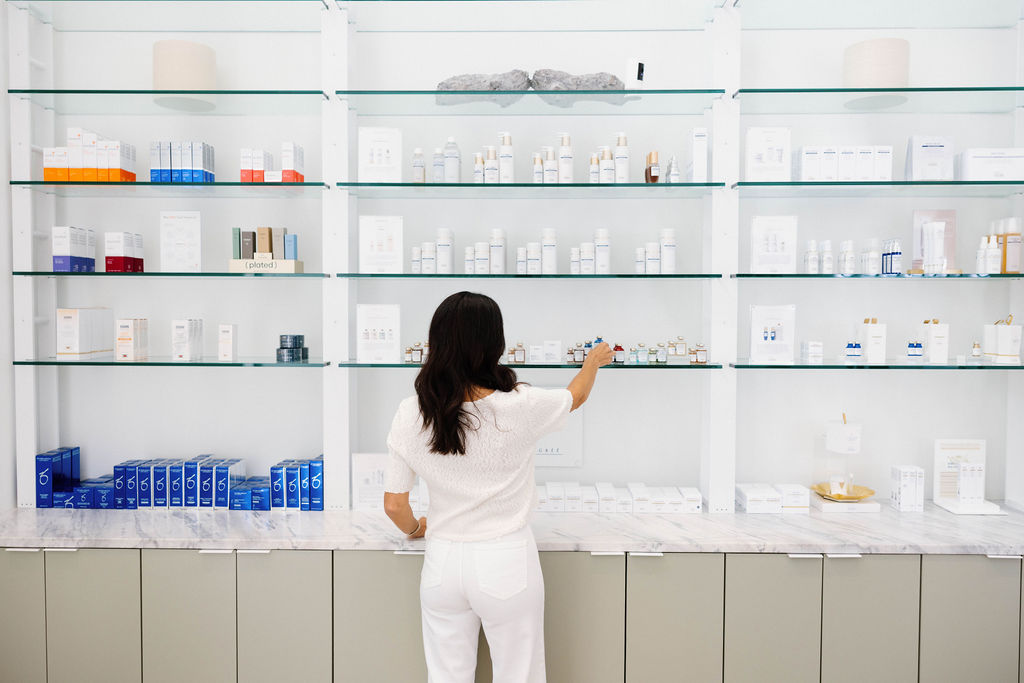 A sunlit clinic retail shelf with skincare products