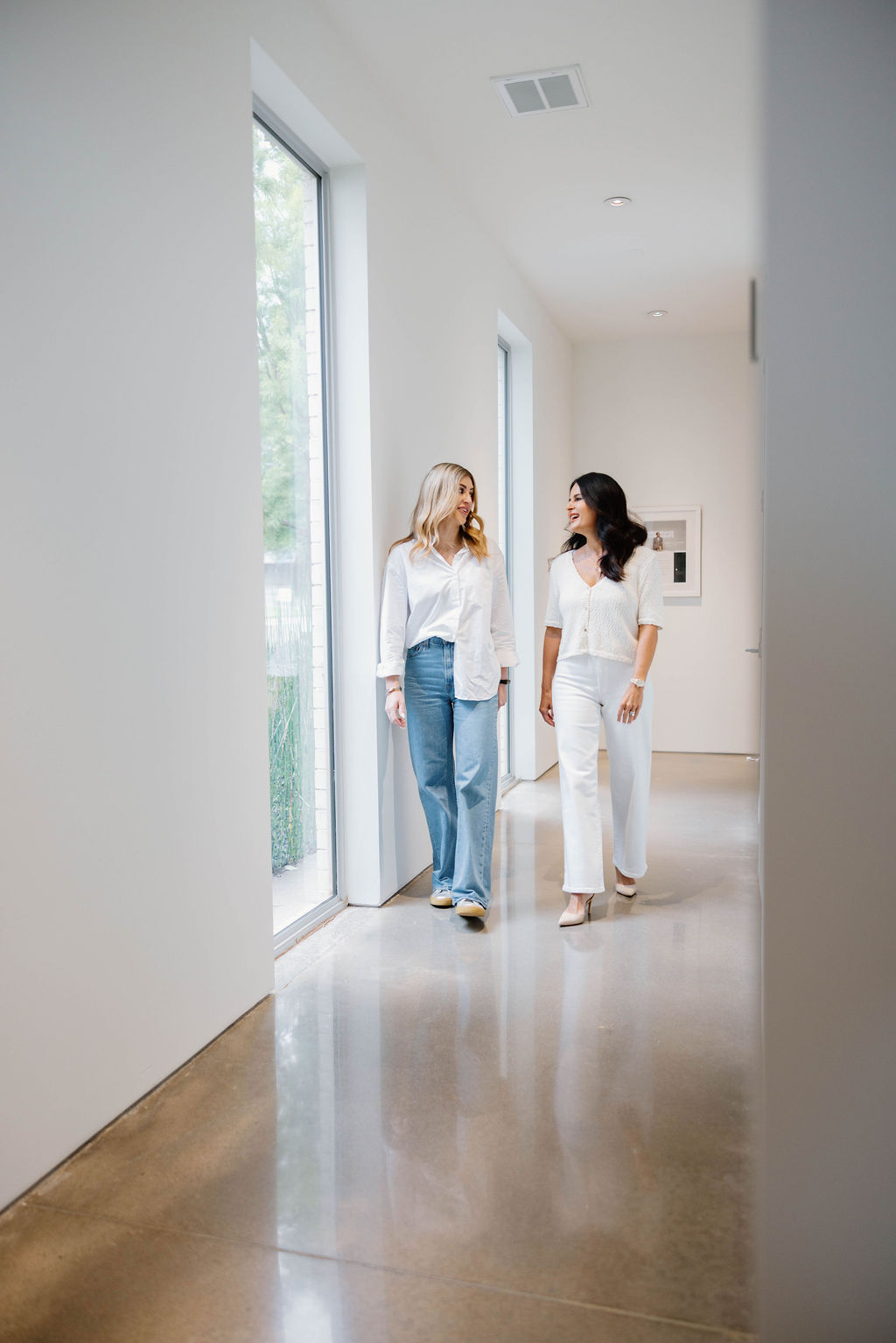 Two clinicians walking a bright clinic corridor